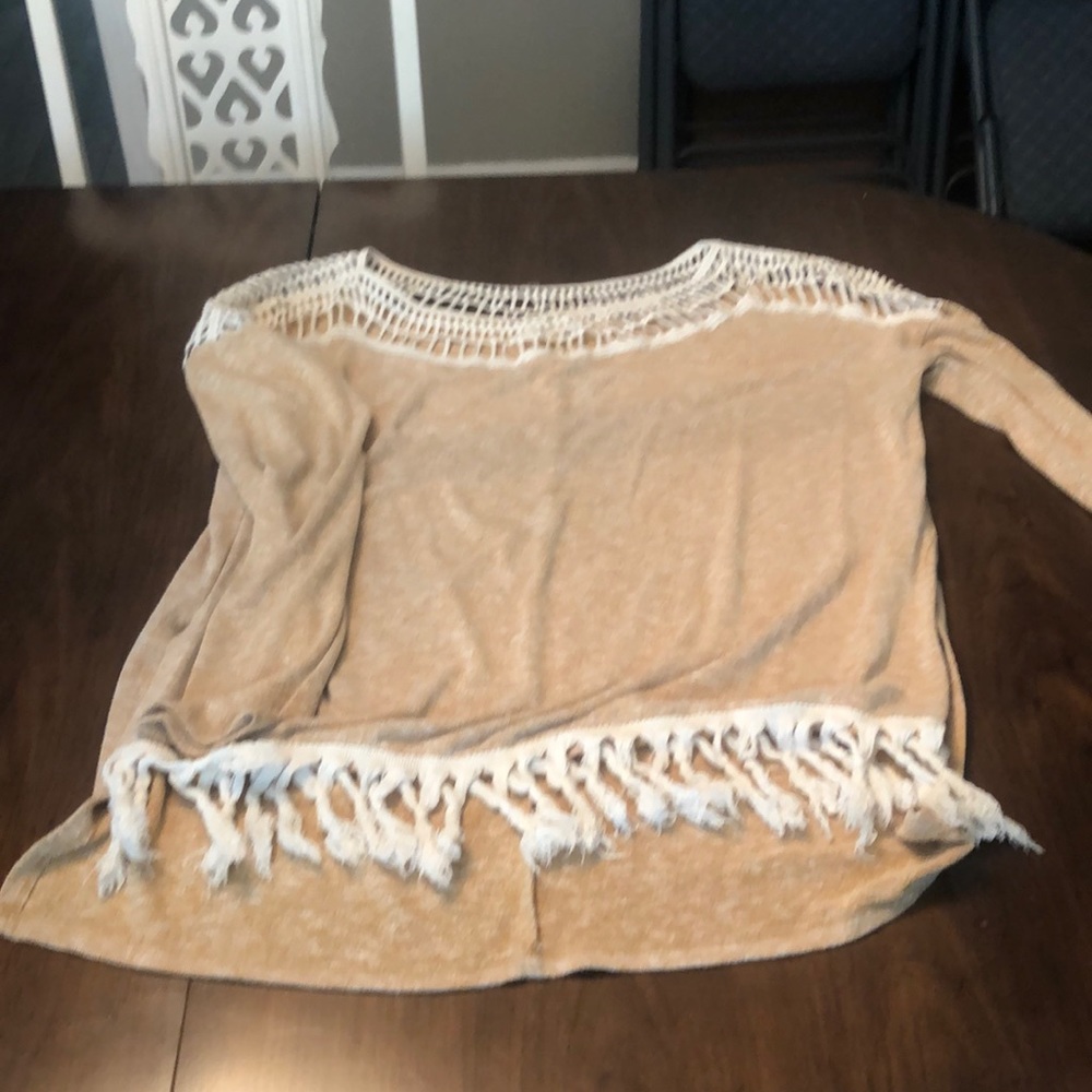 Cream long sleeve top with crocheted top and fringe detail at the bottom